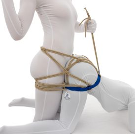 骑马束带 - 一名女性弯腰摆出狗爬式姿势，并使用狗爬式束带用绳子将其固定在该姿势上。第二名女性站在第一名女性的后面，她们可能会发生插入式性爱。第二名女性将自己绑在第一名女性身上，这样她们可以移动而不会分开。