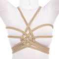 A picture of a woman wearing a white catsuit and a rope harness on her chest. This harness features an attractive woven pattern that centers on the middle of the chest with ropes radiates outward like spiraling sun beams.